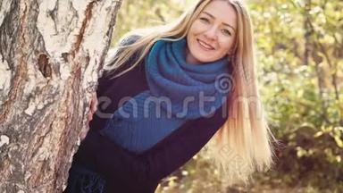 阳光明媚的秋天，年轻的金发美女在五彩缤纷的公园里欢乐的微笑，慢动作。 3840x2160